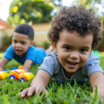 two babies playing in the lawn