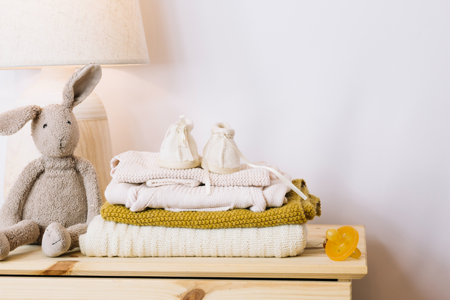Image of a baby doll and some folded baby clothes