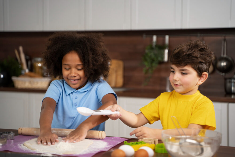 two kids using flour in the kitchen