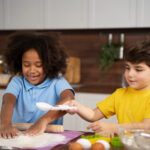 two kids using flour in the kitchen