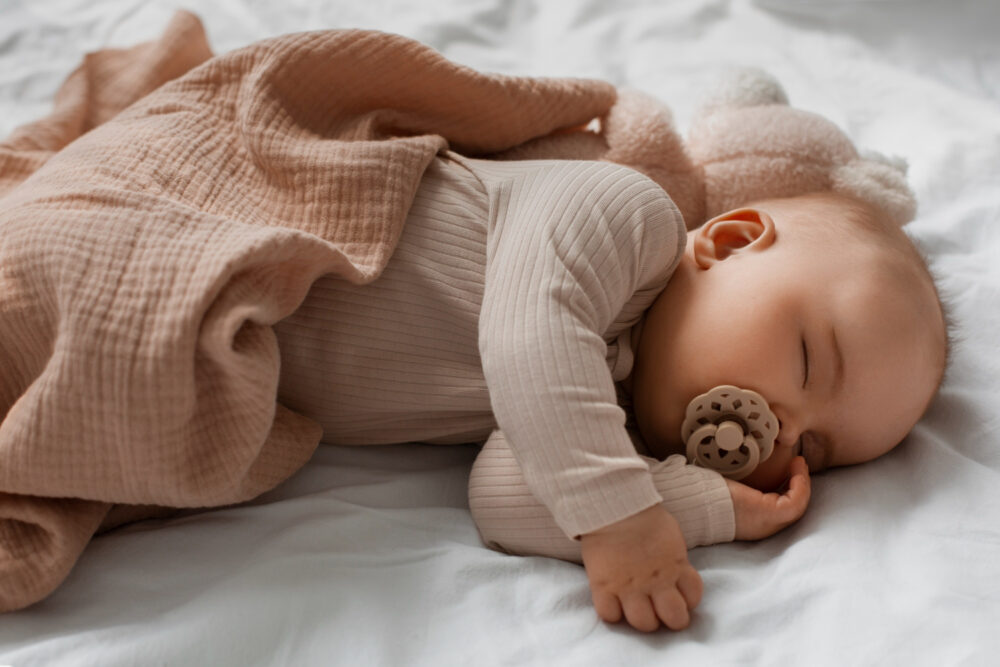 an infant sleeping with a pacifier