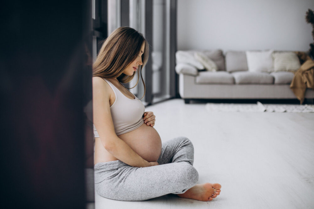 a pregnant woman sitting on the floor