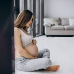 a pregnant woman sitting on the floor