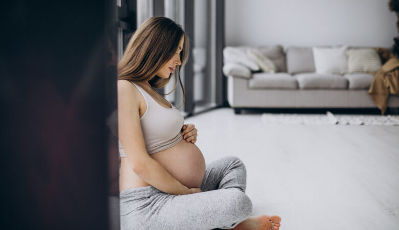 a pregnant woman sitting on the floor