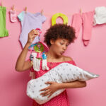 Image of a mom holding a baby hanger and a baby