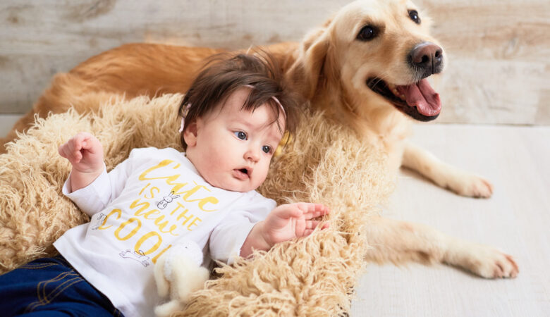 a toddler lying down close to a dog