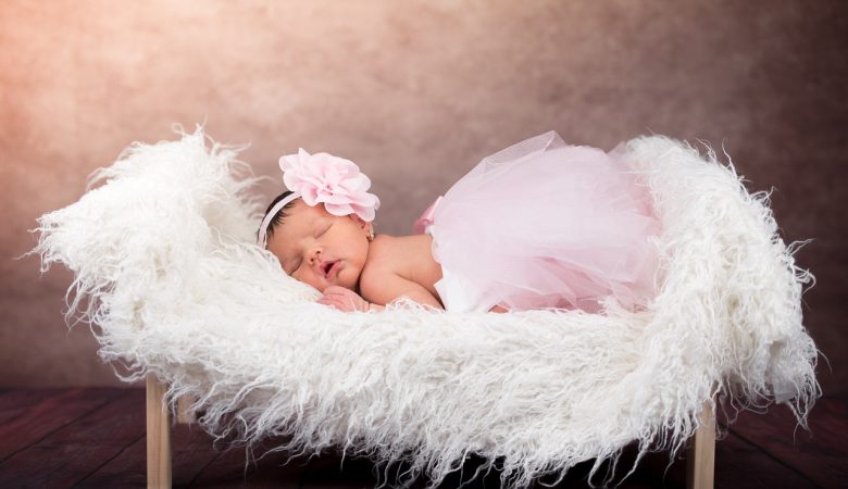 image of an infant baby girl lying in a little fluffy bed