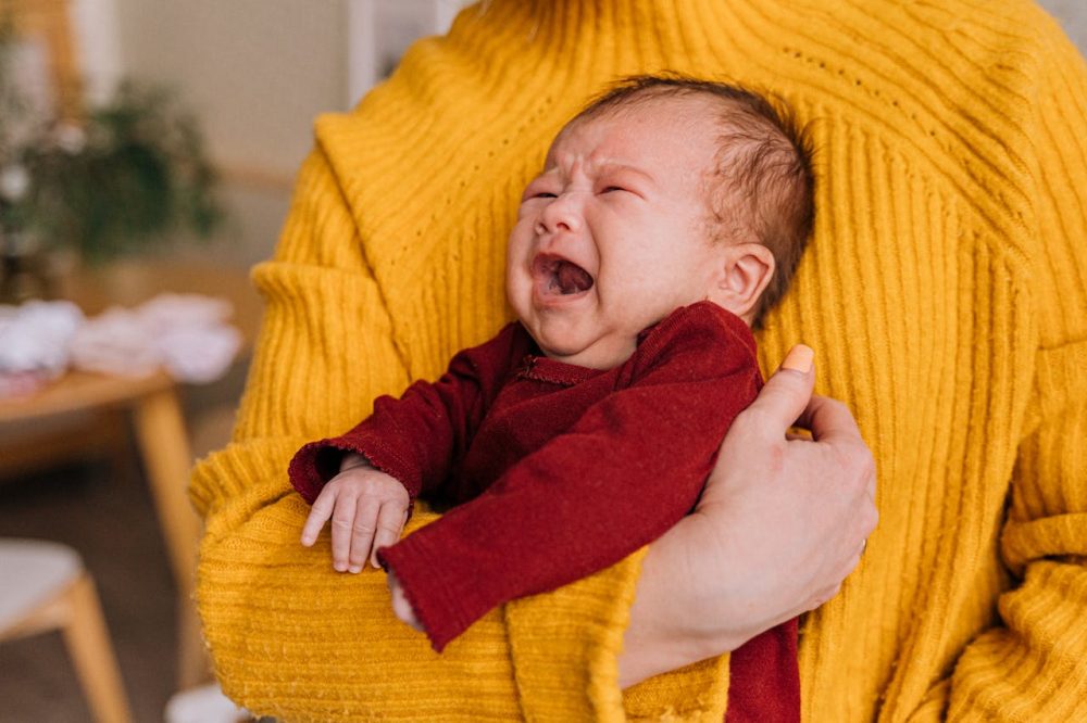 image of a baby crying and being held by mom