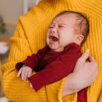 image of a baby crying and being held by mom