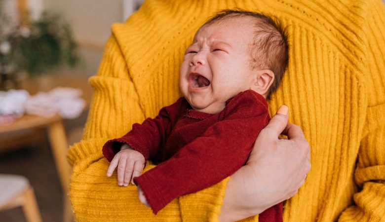 image of a baby crying and being held by mom
