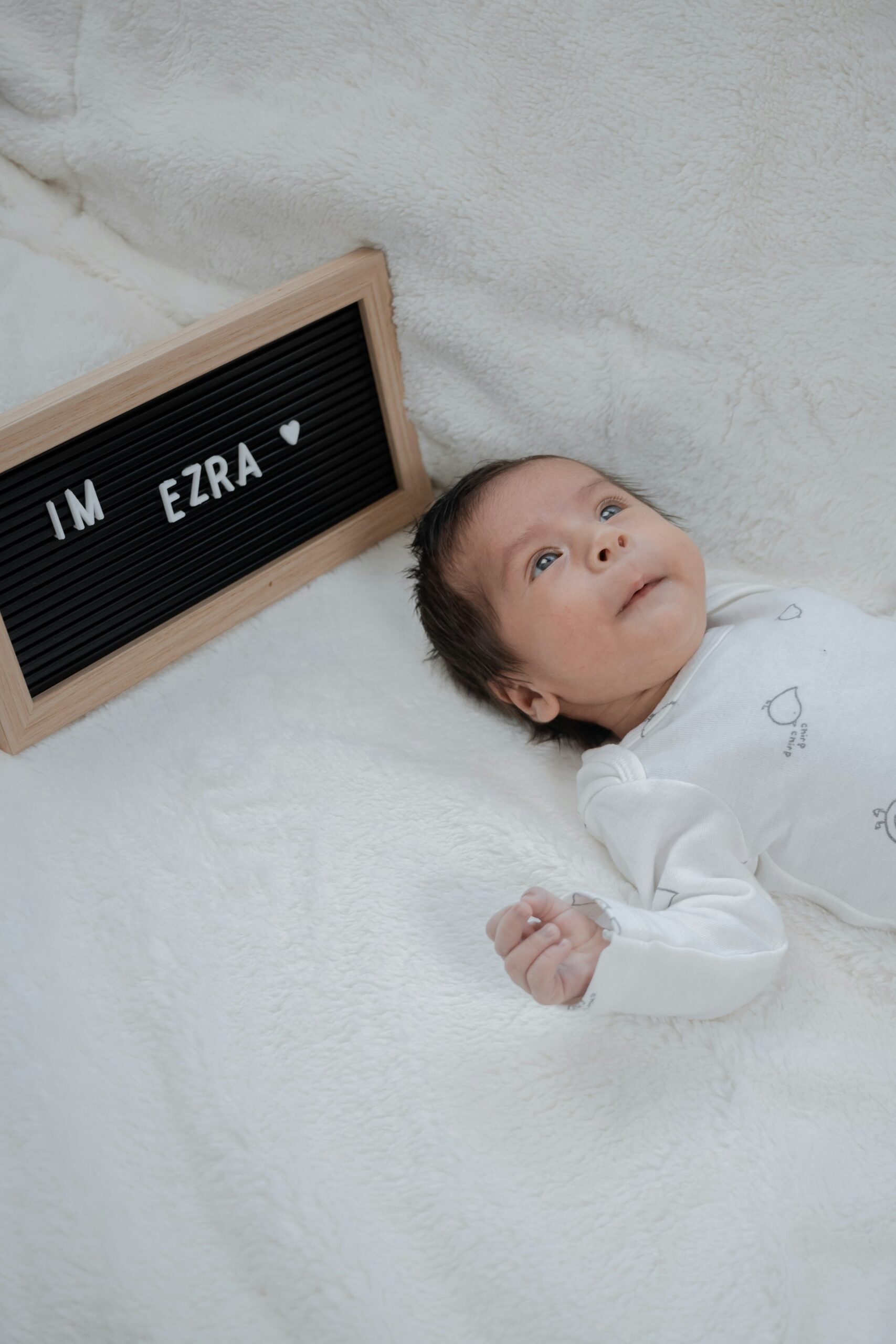 a baby laying down with a name tag above its head