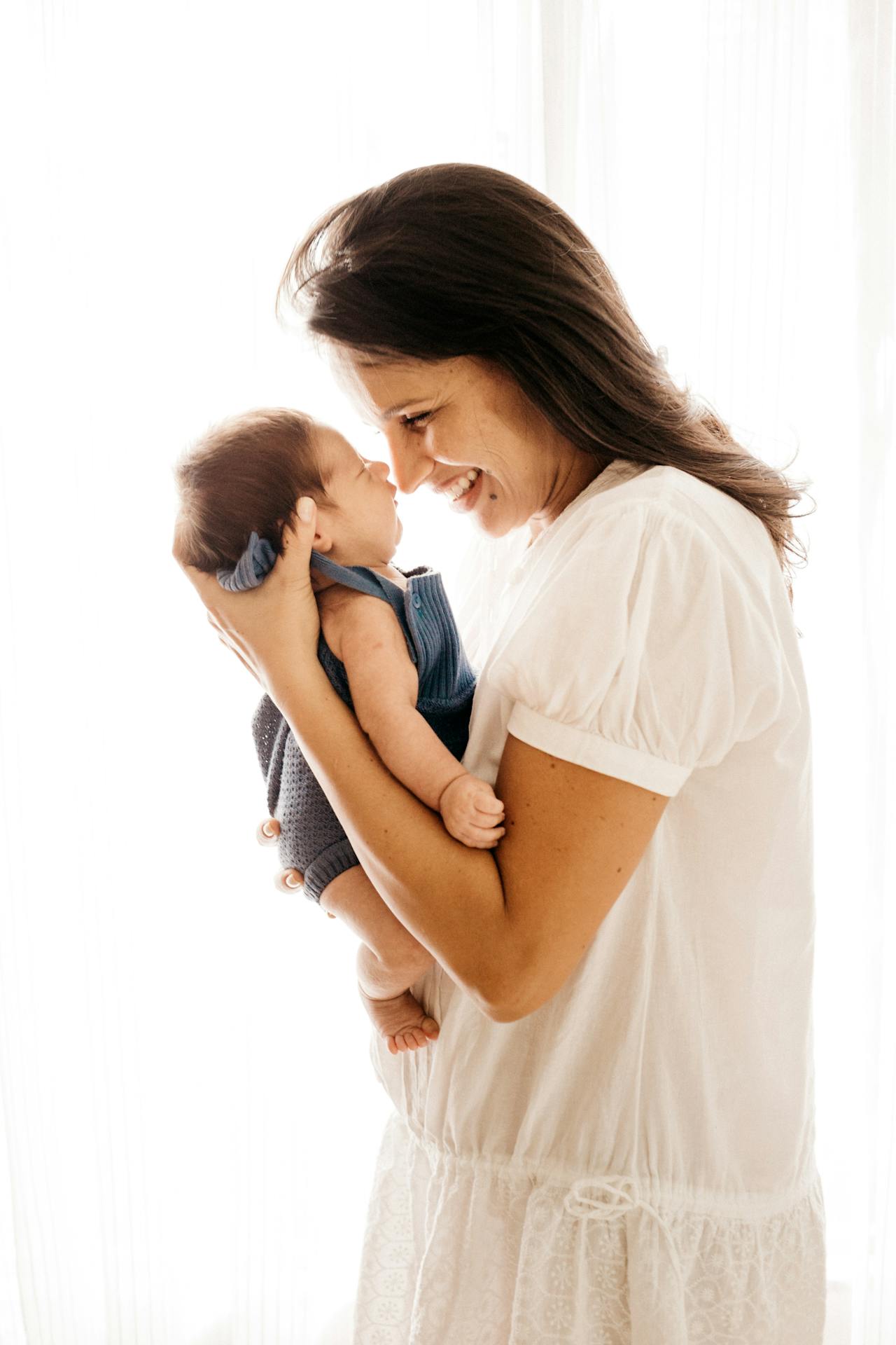 a mom holding her baby and laughing