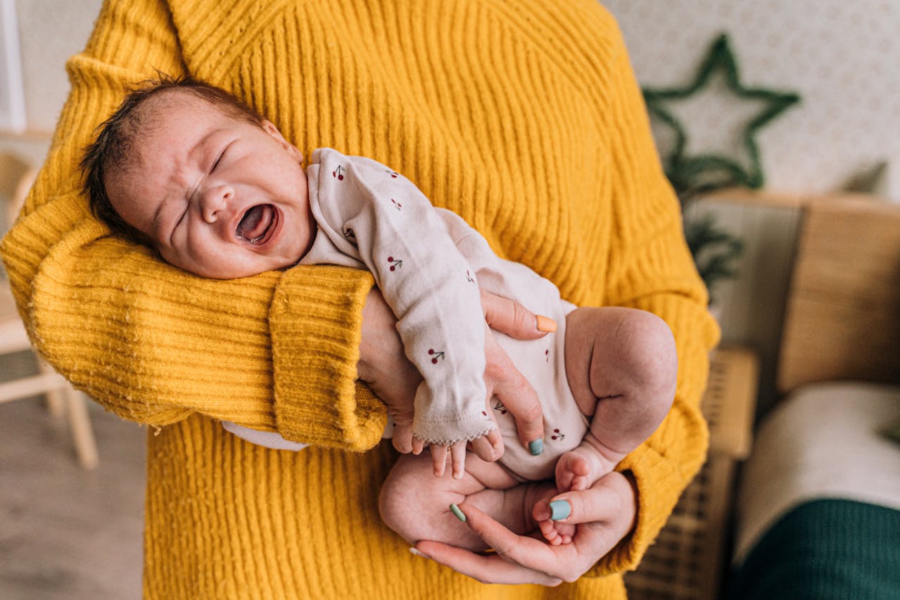 baby crying in mom's arms